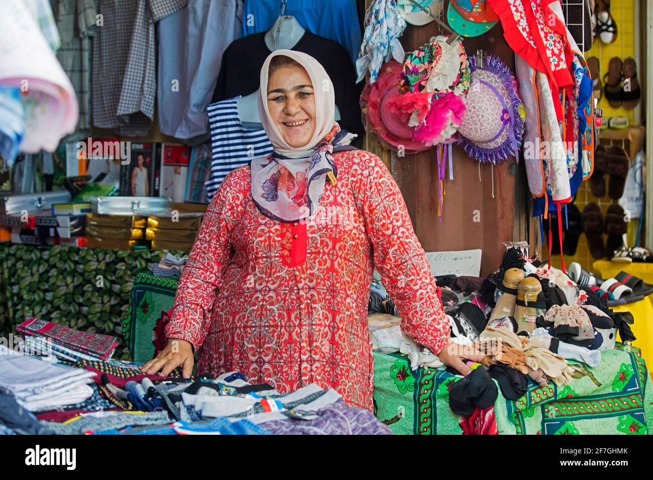 Kyrgyz woman with golden teeth selling clothes at market in the city Osh, Kyrgyzstan Stock Photo