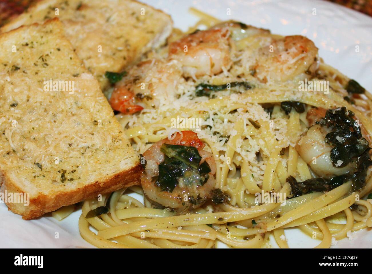 A close-up of a plate of shrimp scampi with garlic bread Stock Photo