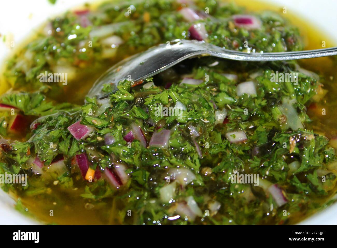 Close-up of a dish of homemade chimichurri sauce, with spoon. Stock Photo