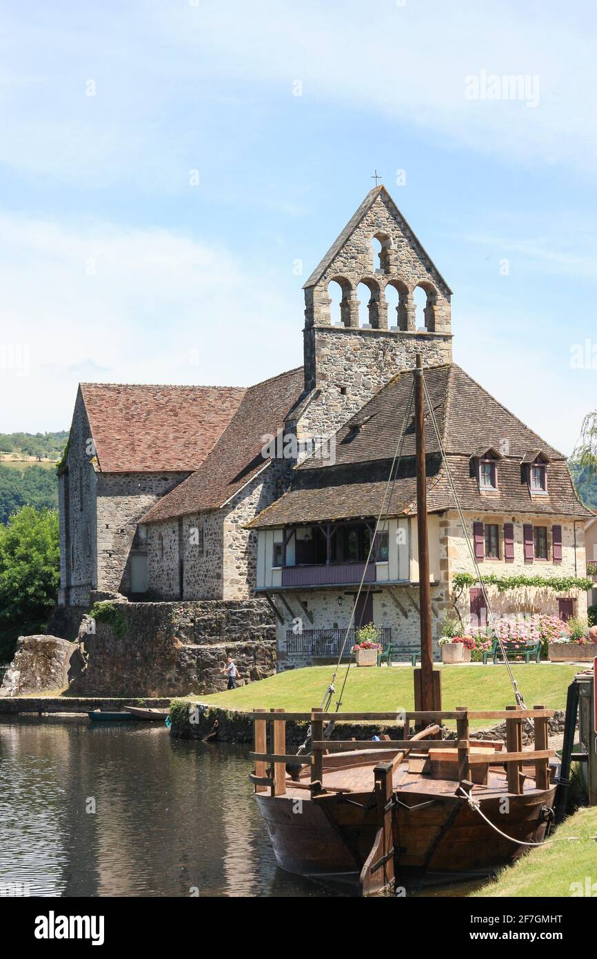 Chapel of the Penitents, Beaulieu sur Dordogne with a traditional boat or Gabarre, Correze, Nouvelle-Aquitaine, France Stock Photo