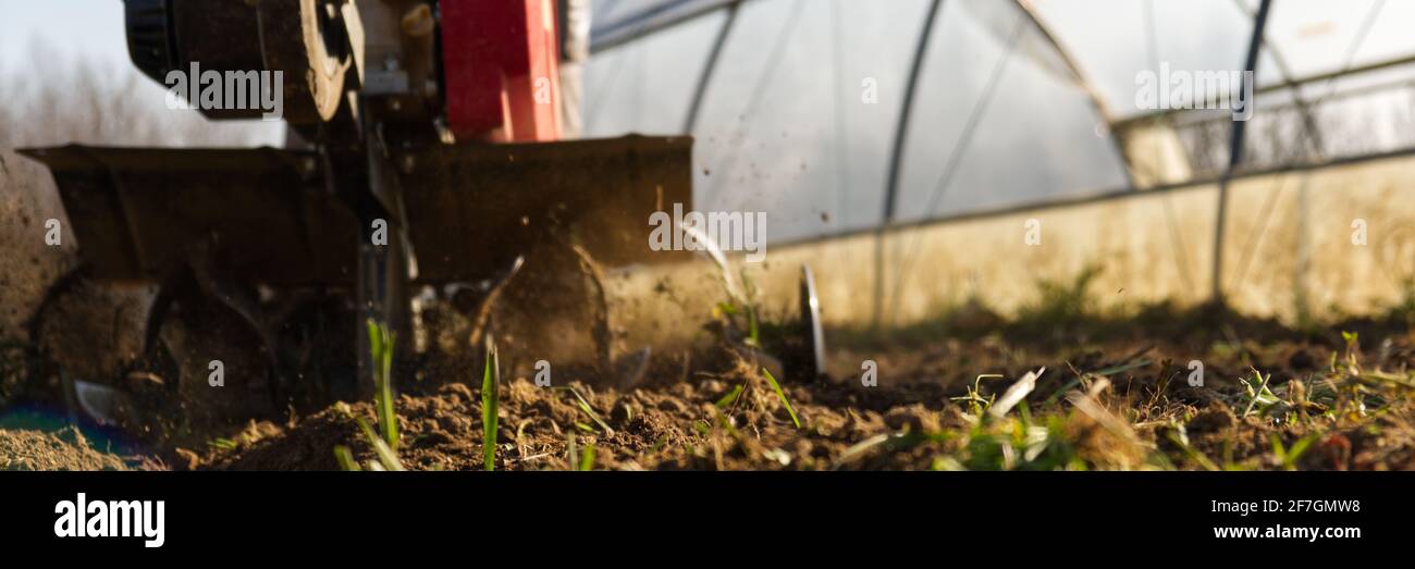 Narrow perspective from the ground of a cutter ploughing the ground Stock Photo