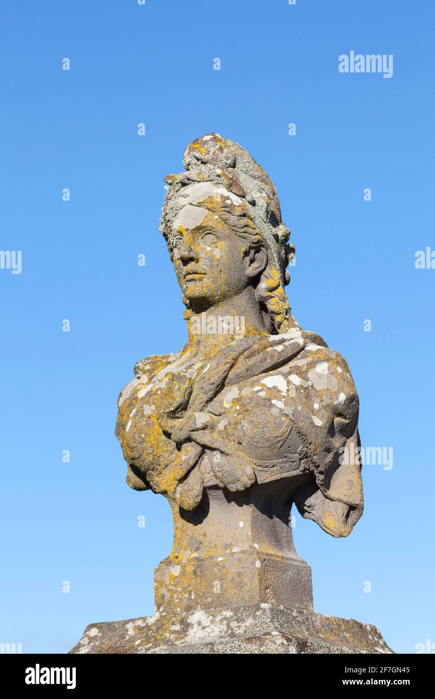 Old weathered stone bust of Marianne, a symbol of  France and the French Republic allegorical of Freedom and Reason, covered in colorful lichen Stock Photo