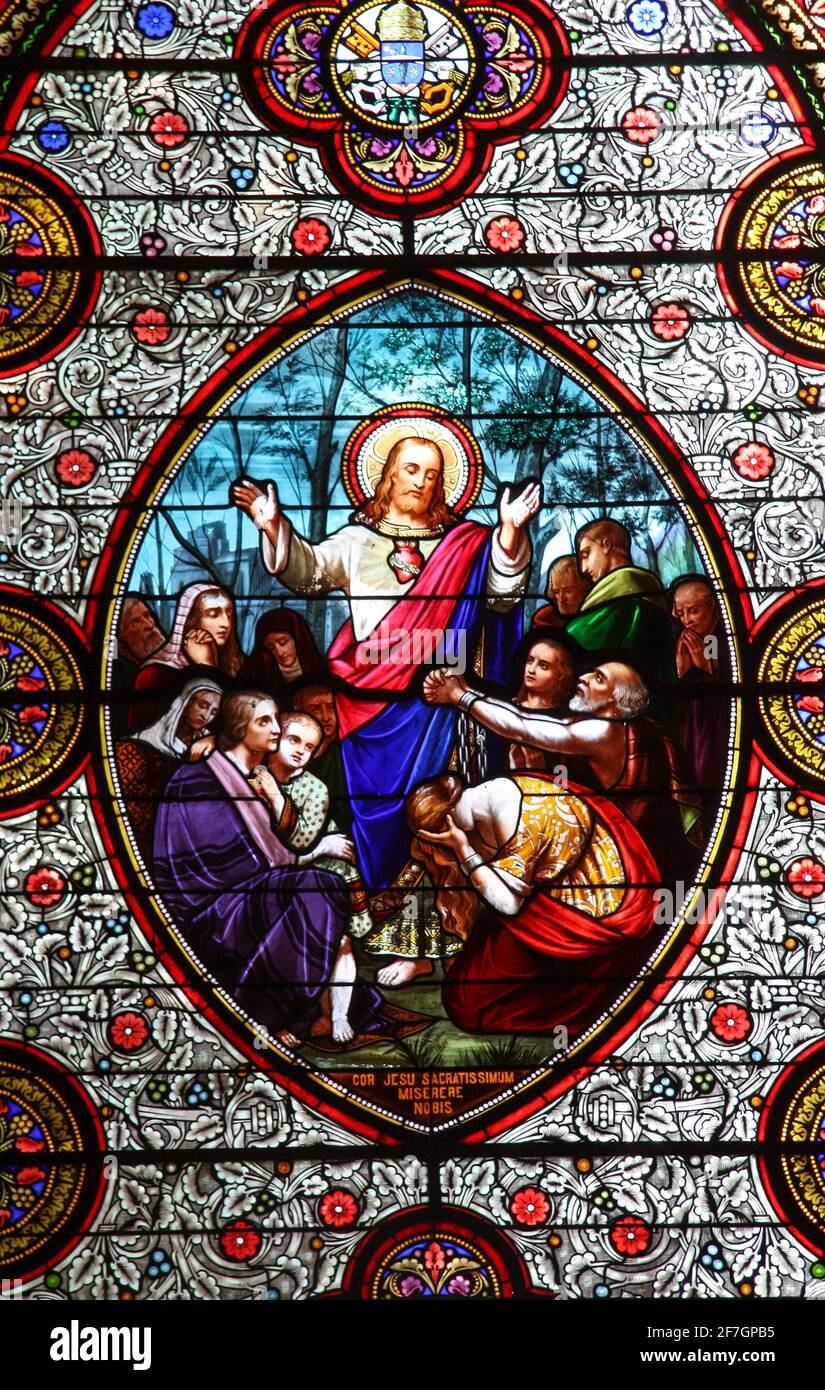 Detail from  a stained glass window in the  medieval abbey at Carrenac, Lot,  France showing Jesus blessing a group of people  offering sinners forgiv Stock Photo