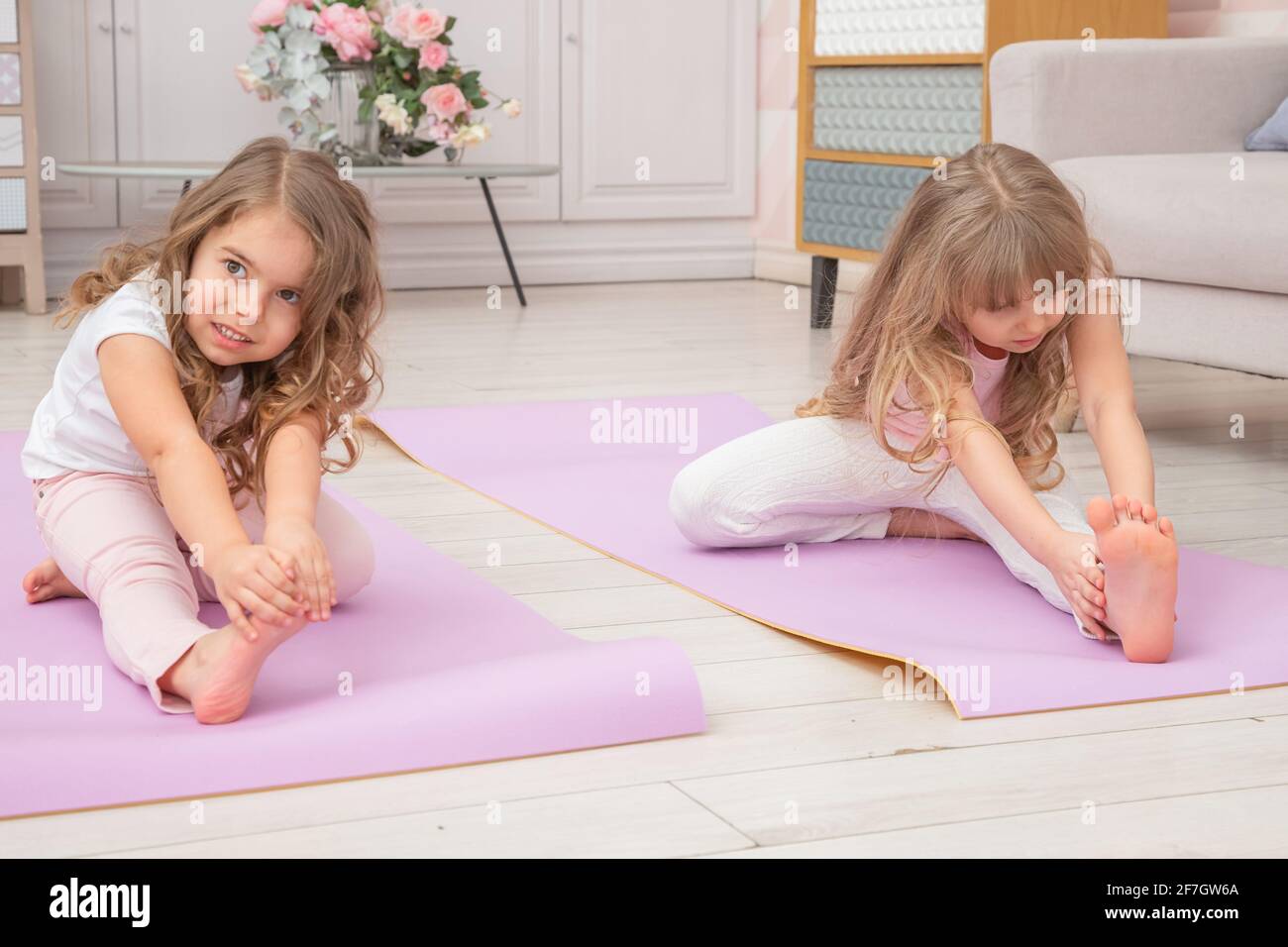 Full length front view smiling cute playful little preschool girls sitting  on on yoga mat do various exercises. Happy kids practicing yoga exercised a  Stock Photo - Alamy