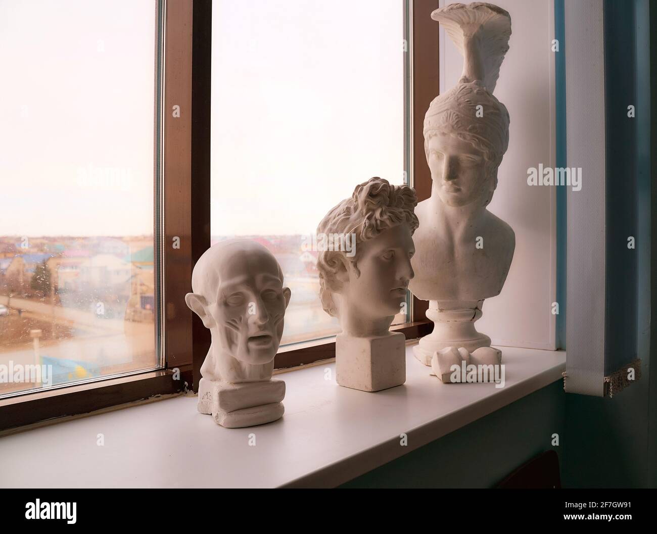 Plaster figures, busts stand on the window sill. Greek statues. High quality photo Stock Photo