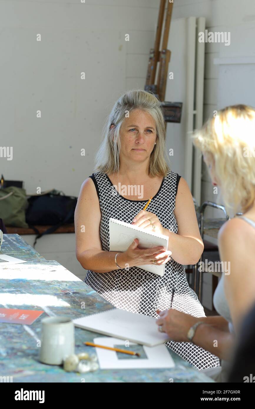 Mature woman drawing picture in sketchbook during her drawing class in