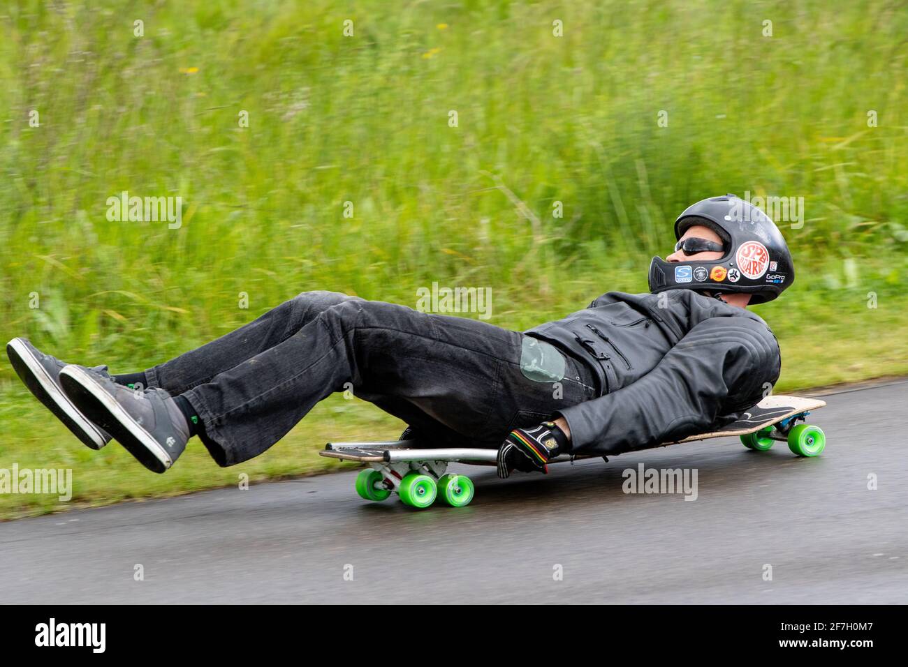 Rolling downhill laying on a skateboard known as buck boarding in the