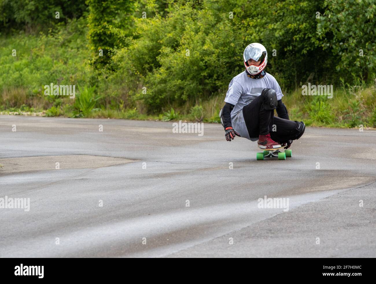 Squatting on a skateboard to corner when going downhill Stock Photo Alamy