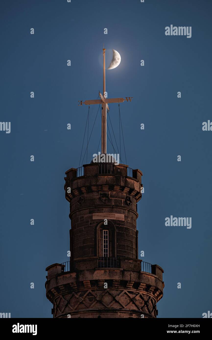 The Nelson Monument on Calton Hill at night in front of the crescent moon. Edinburgh, Scotland Stock Photo