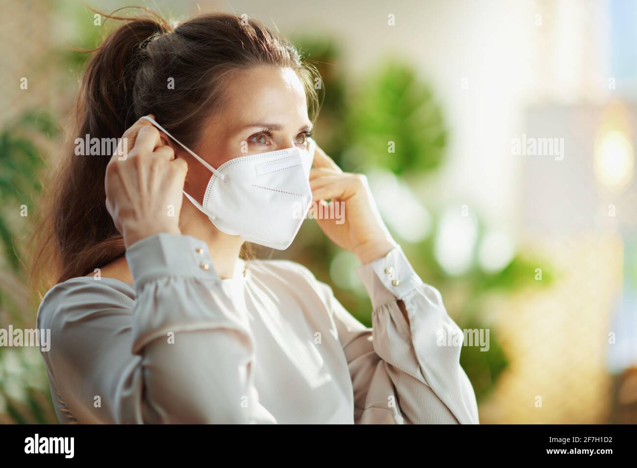 coronavirus pandemic. trendy woman in grey blouse wearing ffp2 mask. Stock Photo