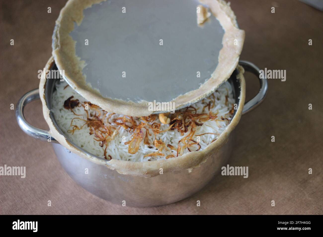 Mutton biriyani inside the open pot after breaking the sealed edges. The edges were sealed for slow cooking the rice. A method for preparing biriyani Stock Photo