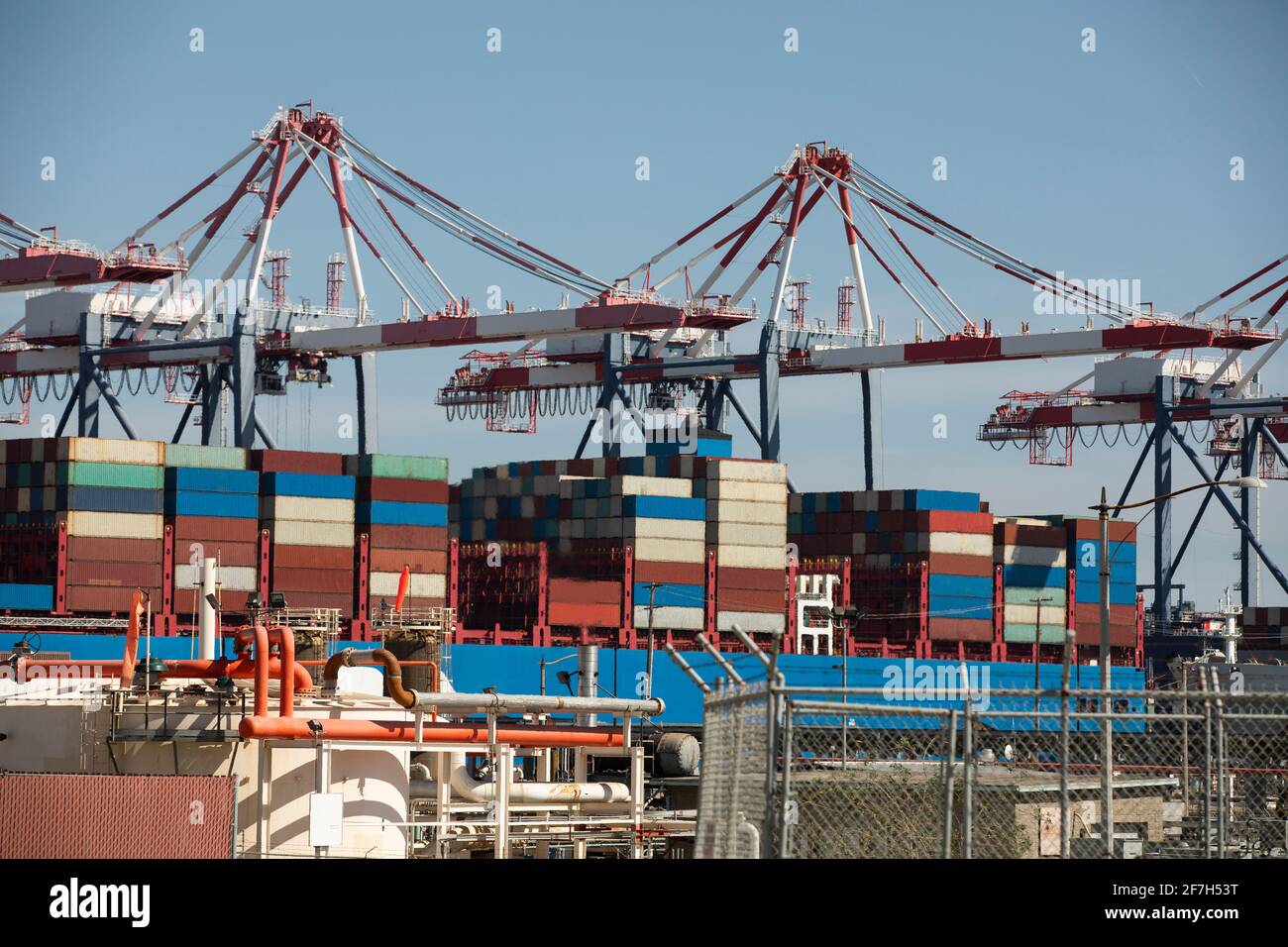 Cargo cranes offload cargo ships at a port Stock Photo - Alamy