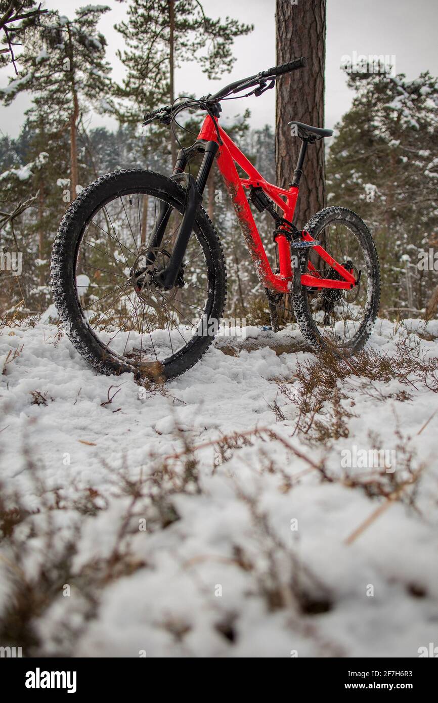 Enduro 27,5 mountain bike in red color resting on a bike single track on a  cold snowy winter day. Concept of extreme sports or mountain biking in cold  Stock Photo - Alamy