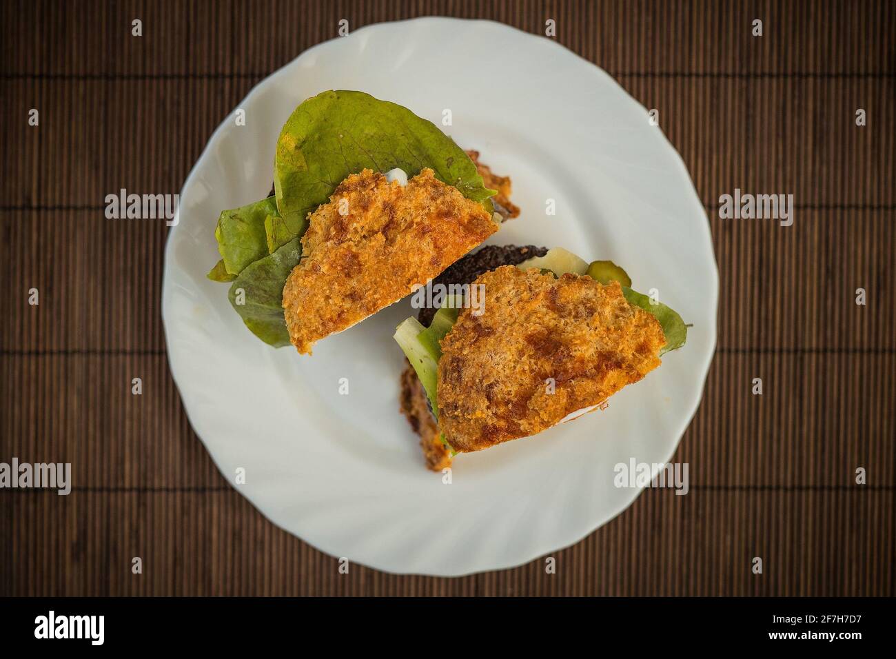 Top view of LCHF Low carbohydrate high fat burger or hamburger meal. LCHF burger with non carbohydrate bread made of sesame, eggs, chees, almonds. Con Stock Photo