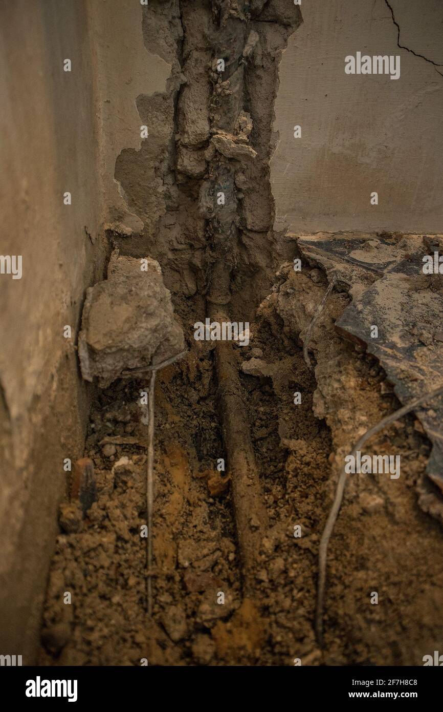 Broken water pipe in an apartment. Visible hole in the ground with