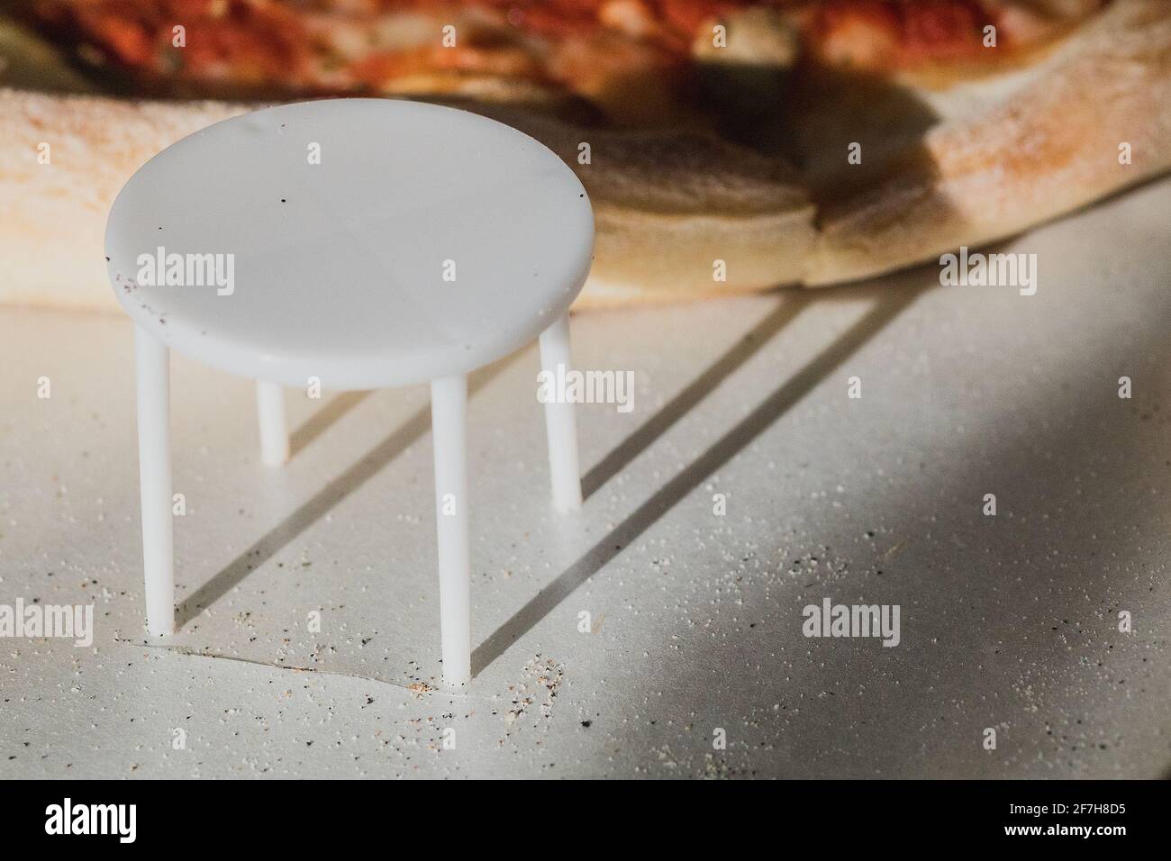 White plastic pizza saver with four legs. A plastic table to save the pizza being squished in