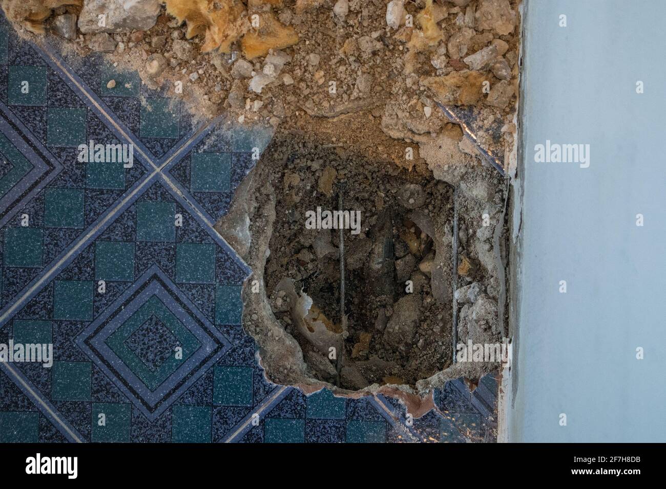 Broken water pipe in an apartment. Visible hole in the ground with