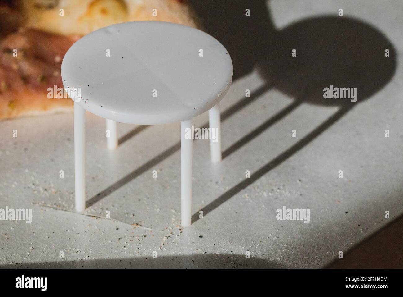 White plastic pizza saver with four legs. A plastic table to save the