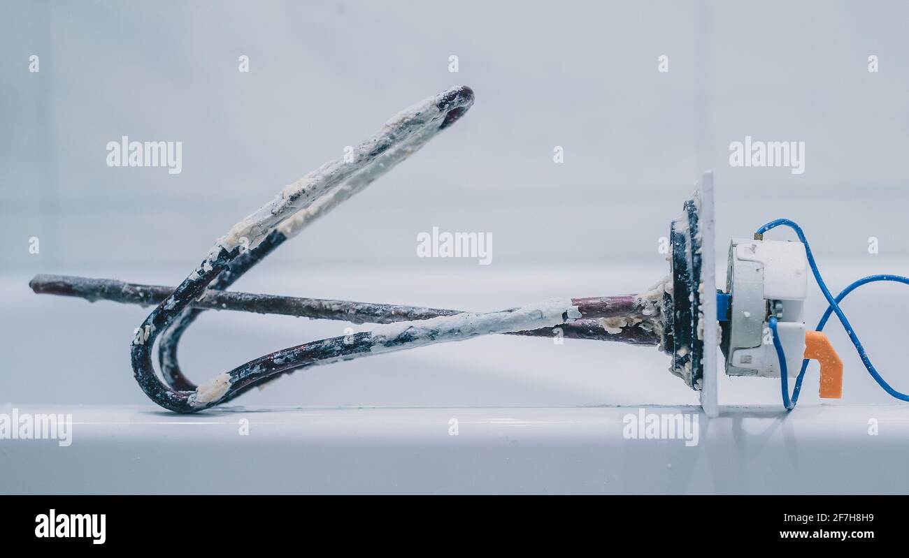Removed electric heater from boiler or water heater to clean lime scale  residue on it as part of maintenance. Side view of a thermostat heater from  b Stock Photo - Alamy