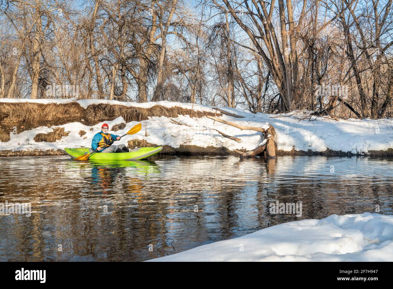 senior male paddler is paddling an inflatable whitewater kayak on a ...