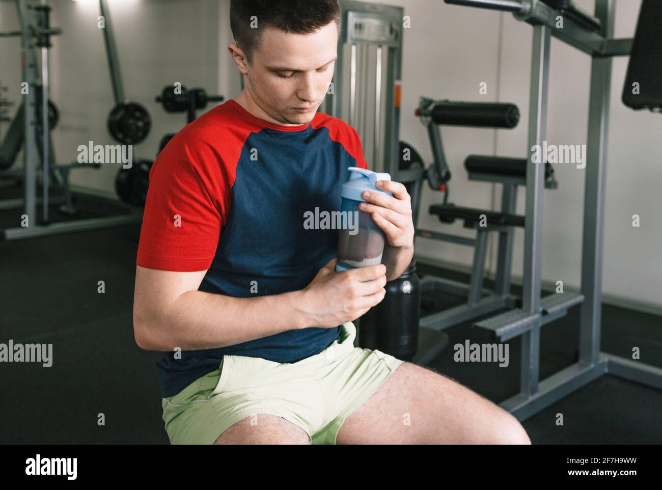the athlete holds a shaker with a protein shake after training. sports
