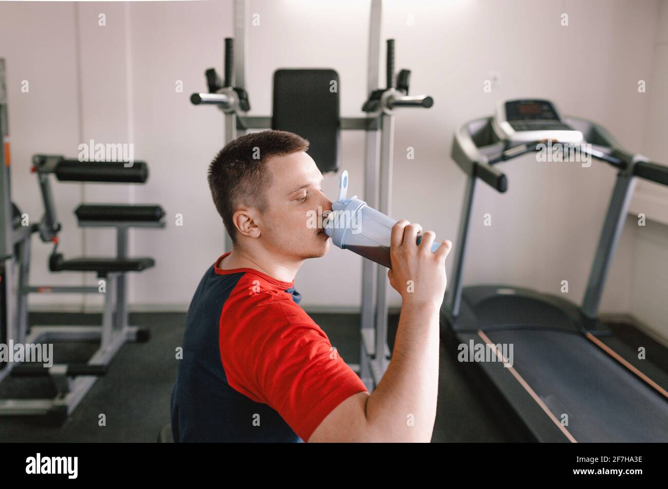 an athlete drinks a protein shake from a shaker after training. sports