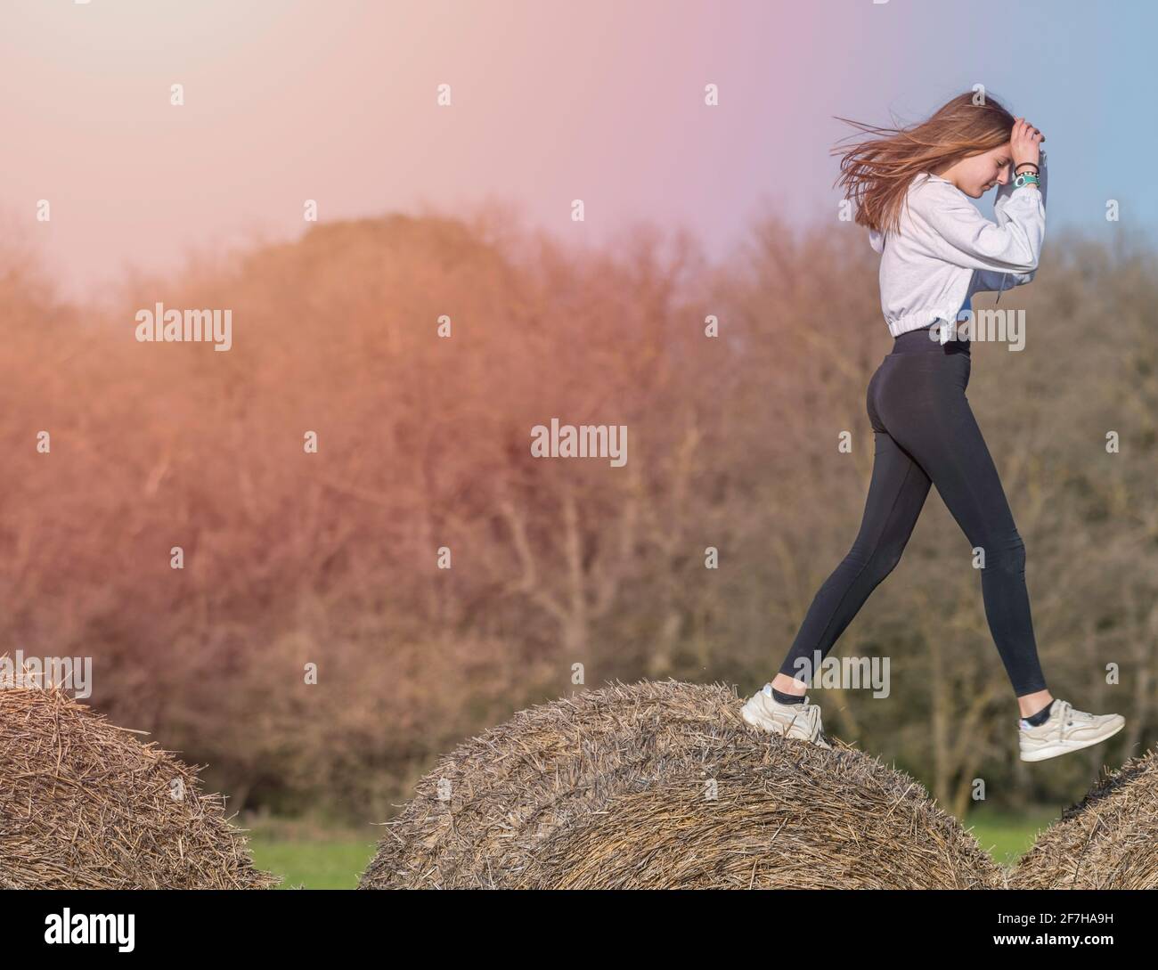 latina teenage girl in black leggings, top and jacket posing on straw bales  in rural setting Stock Photo - Alamy