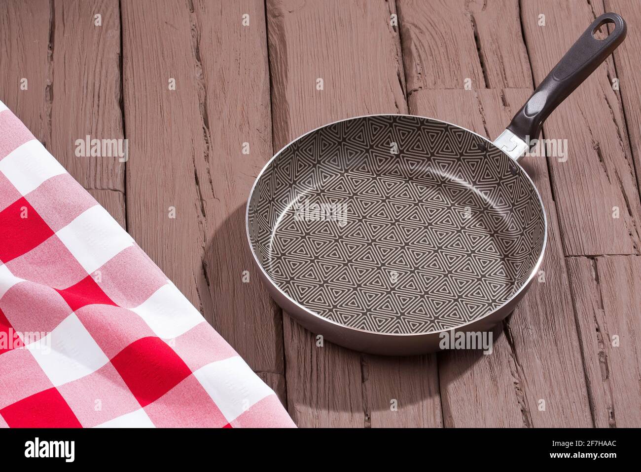 Nonstick skillet with glass lid. Wooden background Stock Photo