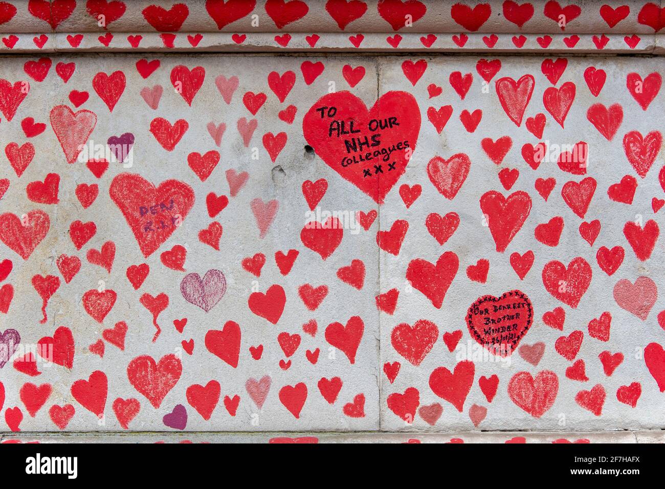 A message on a heart for the NHS workers who lost their lives seen on the National Covid Memorial Wall.The wall is adjacent to St Thomas' Hospital and is being hand-painted with 150000 hearts to honour UK Covid-19 victims, it stretches over 700 metres long. Stock Photo
