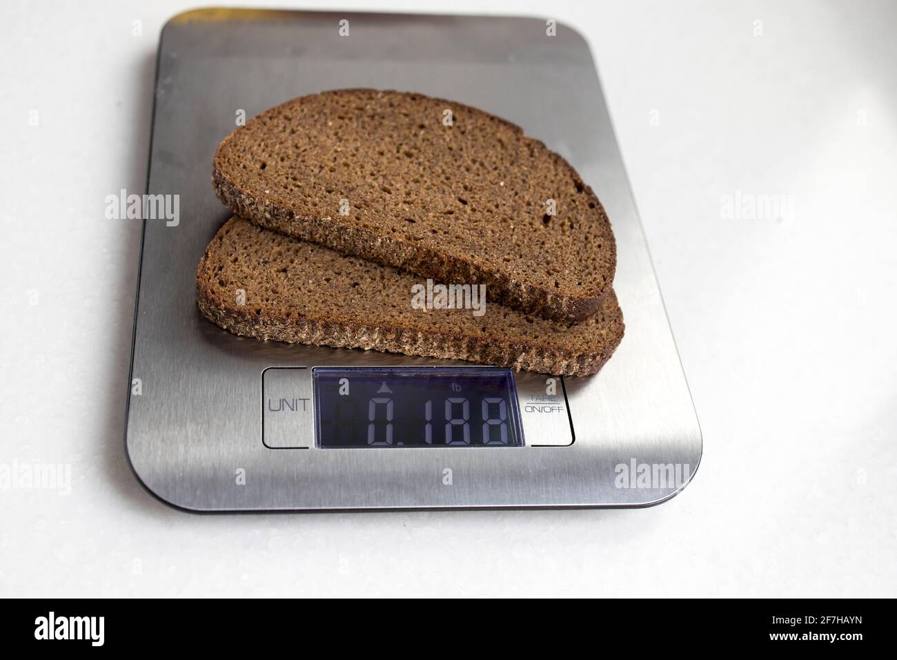 Two pieces of rye bread are weighed on a kitchen scale. Diet Stock Photo -  Alamy