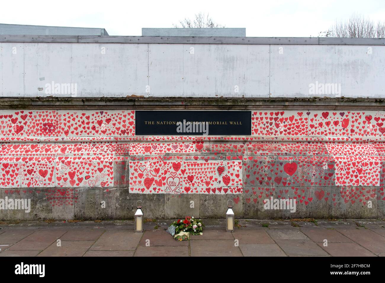London, UK. 07th Apr, 2021. Flowers left at the National Covid Memorial Wall.The wall is adjacent to St Thomas' Hospital and is being hand-painted with 150000 hearts to honour UK Covid-19 victims, it stretches over 700 metres long. (Photo by Dave Rushen/SOPA Images/Sipa USA) Credit: Sipa USA/Alamy Live News Stock Photo