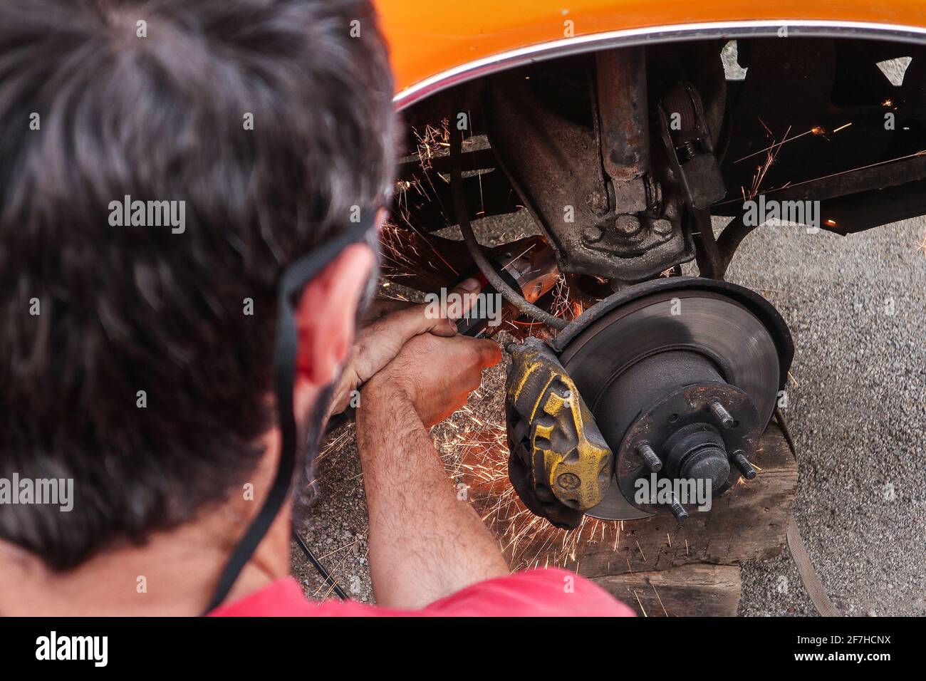 Amateur car mechanic is lowering a car with cutting the springs. Cheap