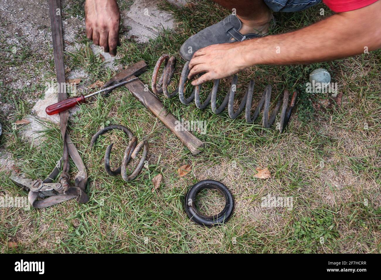 Amateur car mechanic is lowering a car with cutting the springs. Cheap