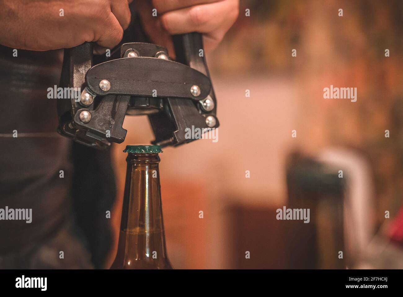 Detail of a tool for closing or bottling beer bottles. Man closing a