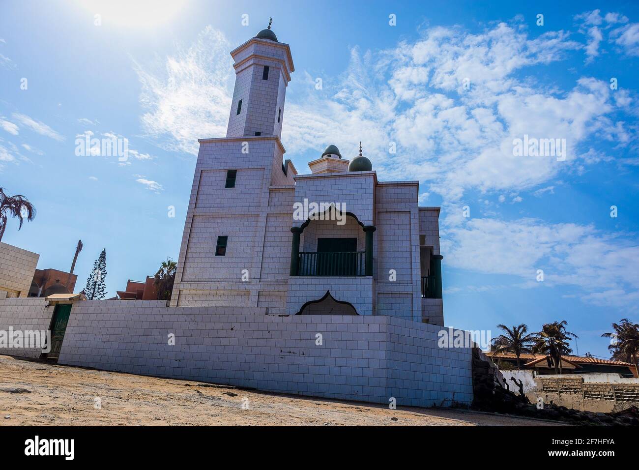 Grand Mosque de Warar, white and green islamic church on the edge of the beach in Tonghor, Dakar, on a sunny day with some clouds. Stock Photo