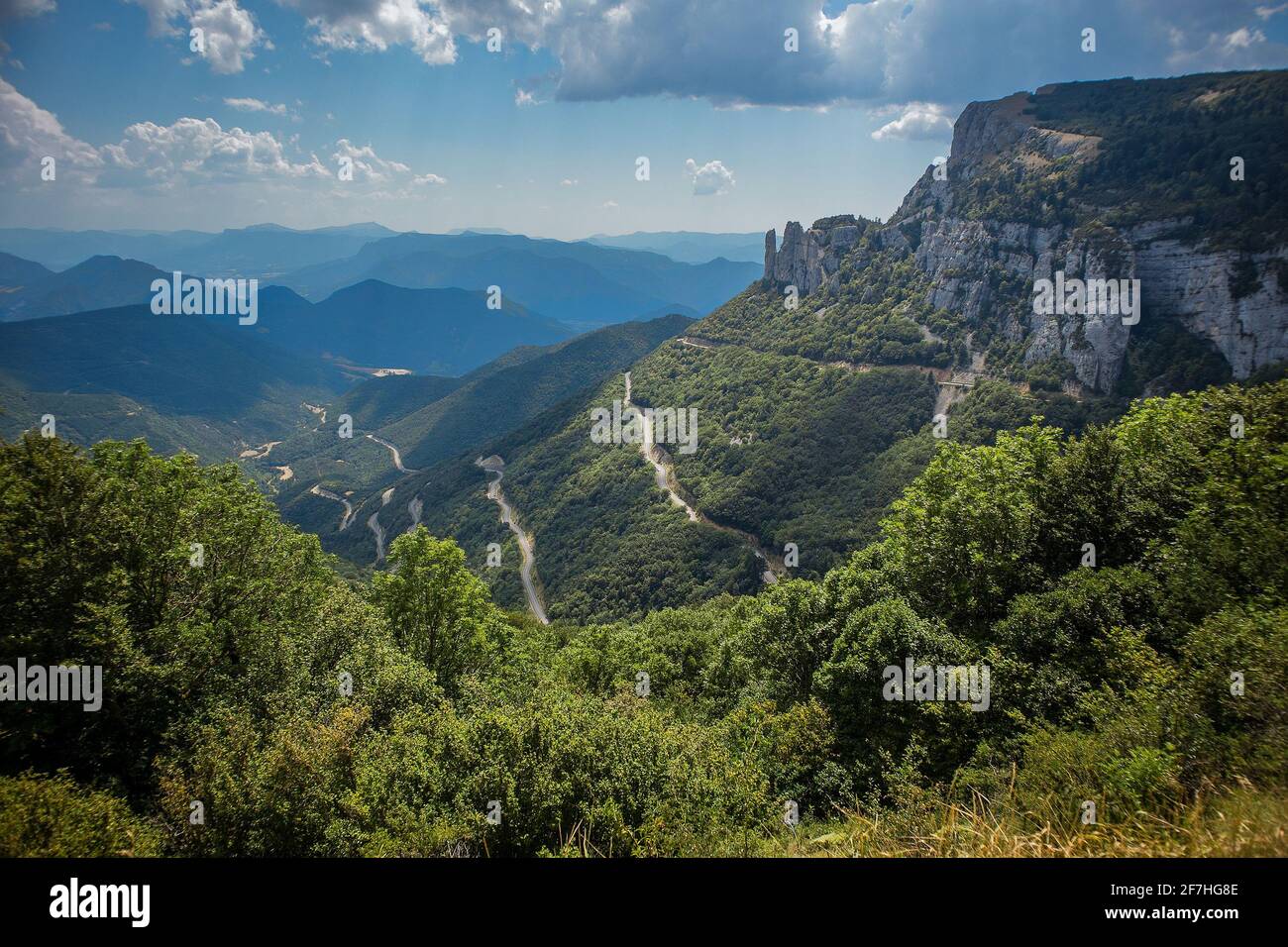 View from Col de Rousset in France. Winding road with twisties and sharp turns viewed from observation point on a cloudy day with some trees in the ba Stock Photo