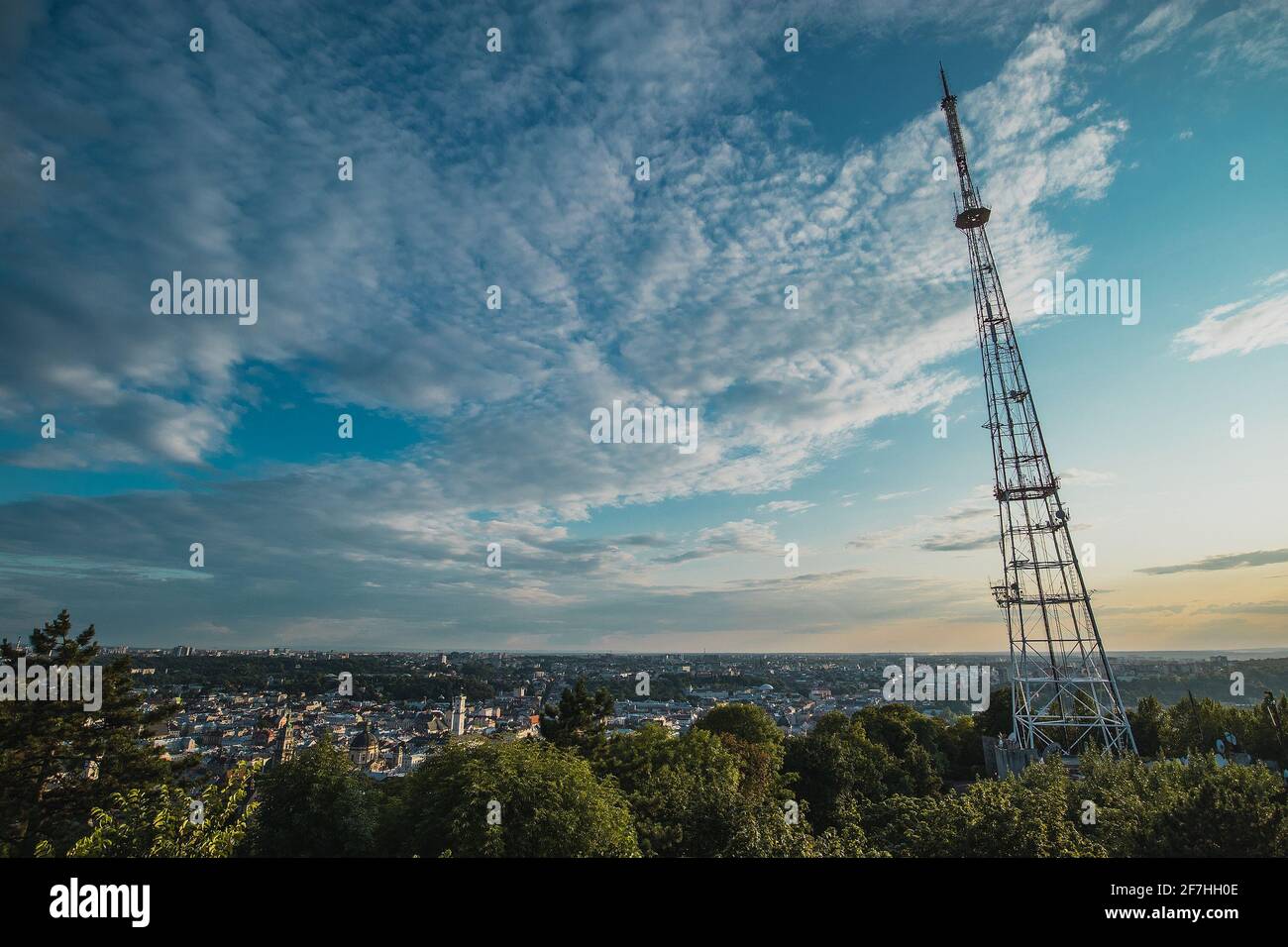 Panorama photo of Lviv city center viewed from High Park castle observation point way above the city at romantic summer sunset. High radio antenna tow Stock Photo
