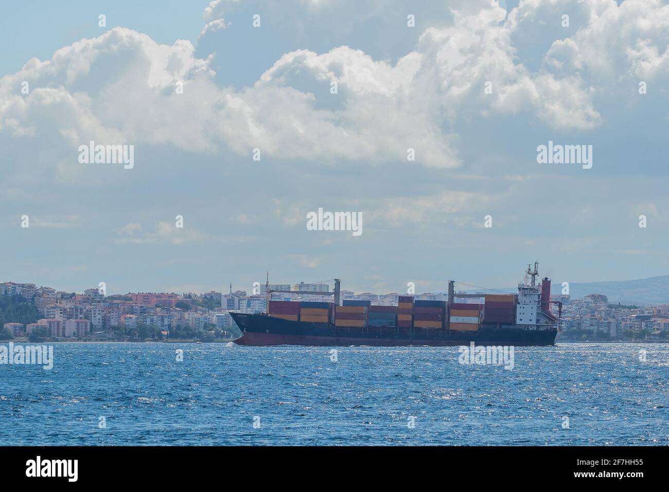 A big container cargo ship or carrier traveling through the Dardanele strait in Turkey on a