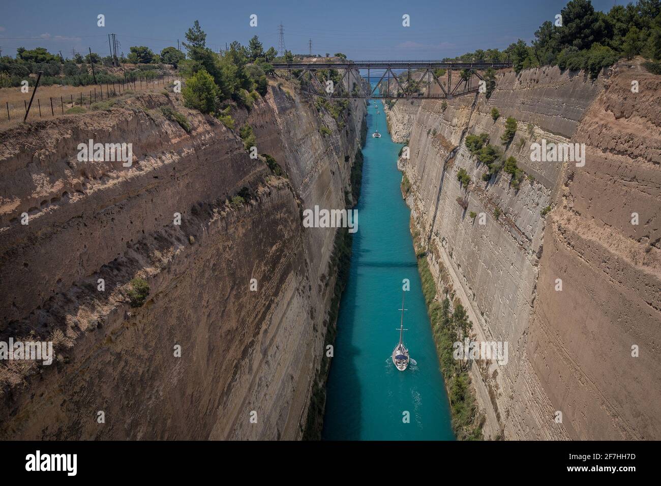 Corinth or corinthian canal in Greece. A narrow waterway that connects Ionic sea with Aegean sea. Narrow water passage carved in rock on a sunny day. Stock Photo