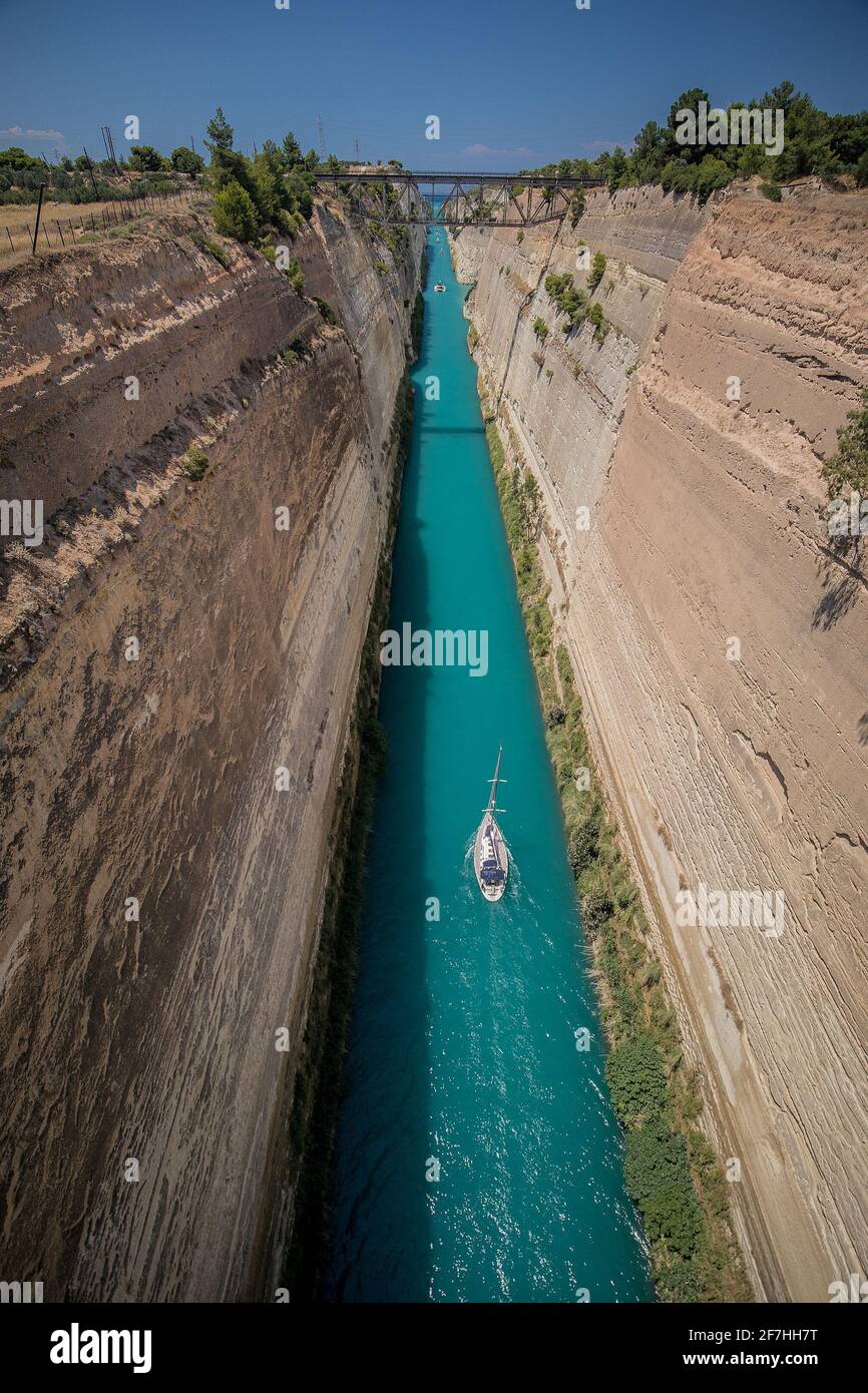 Corinth or corinthian canal in Greece. A narrow waterway that connects Ionic sea with Aegean sea. Narrow water passage carved in rock on a sunny day. Stock Photo