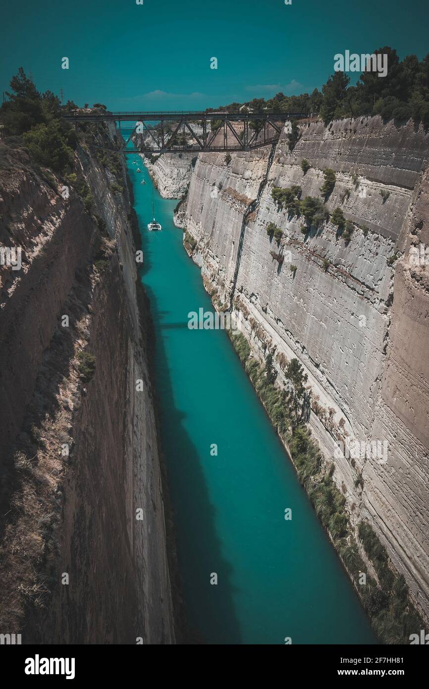 Corinth or corinthian canal in Greece. A narrow waterway that connects Ionic sea with Aegean sea. Narrow water passage carved in rock on a sunny day. Stock Photo