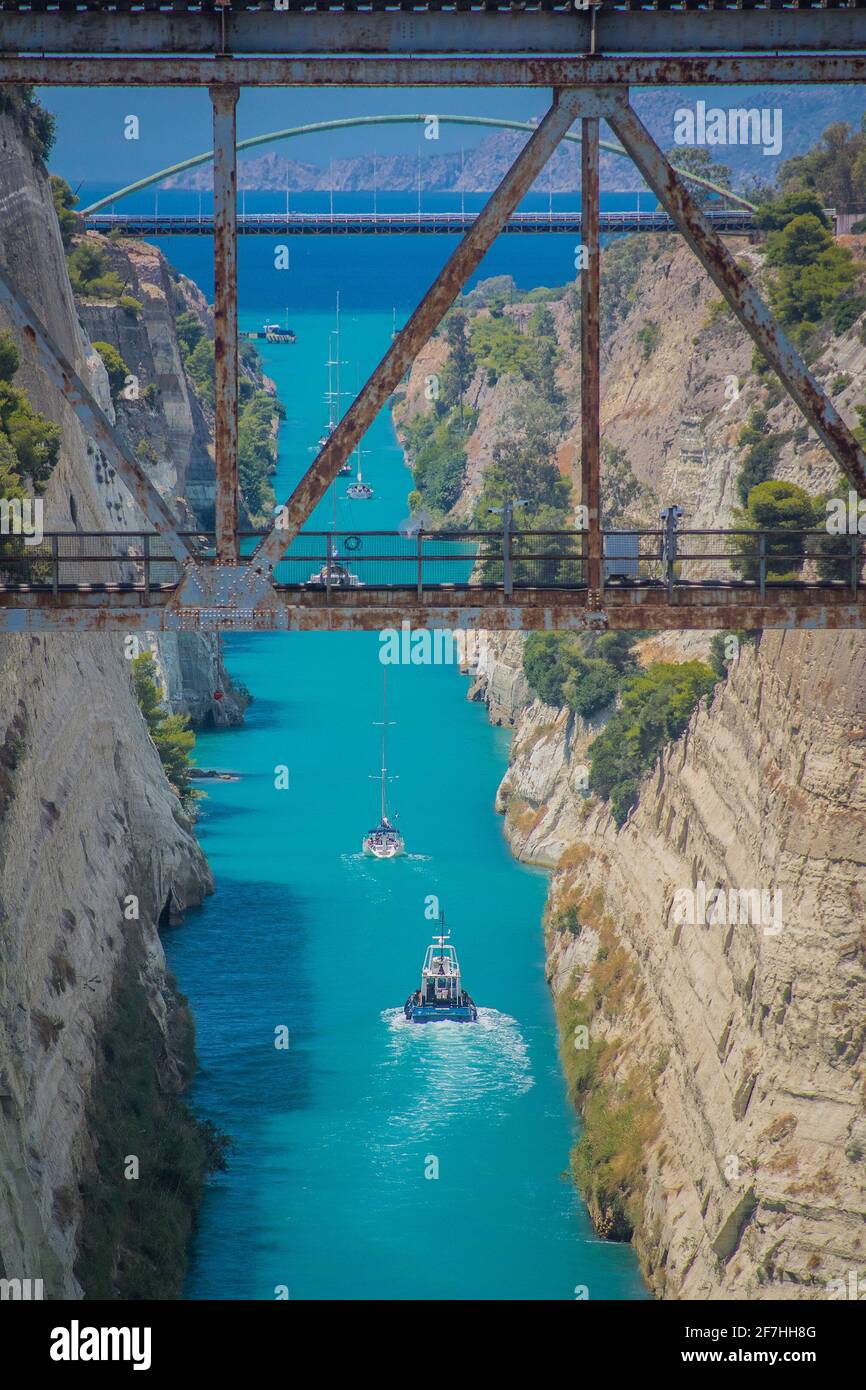 Corinth or corinthian canal in Greece. A narrow waterway that connects Ionic sea with Aegean sea. Narrow water passage carved in rock on a sunny day. Stock Photo