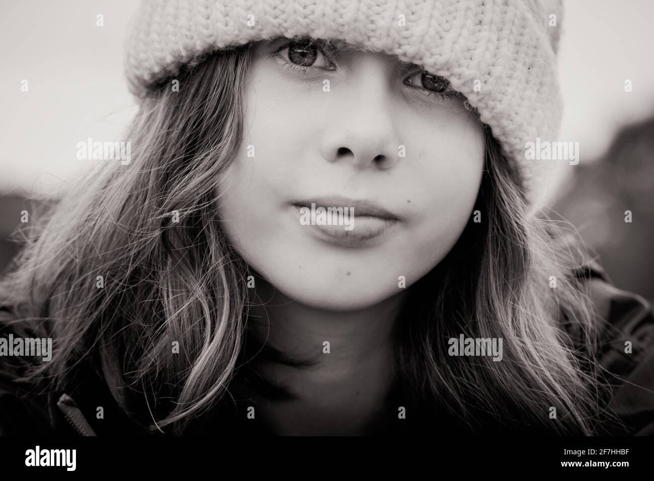 A beautiful tween girl model outside in winter in a knitted beanie hat Stock Photo