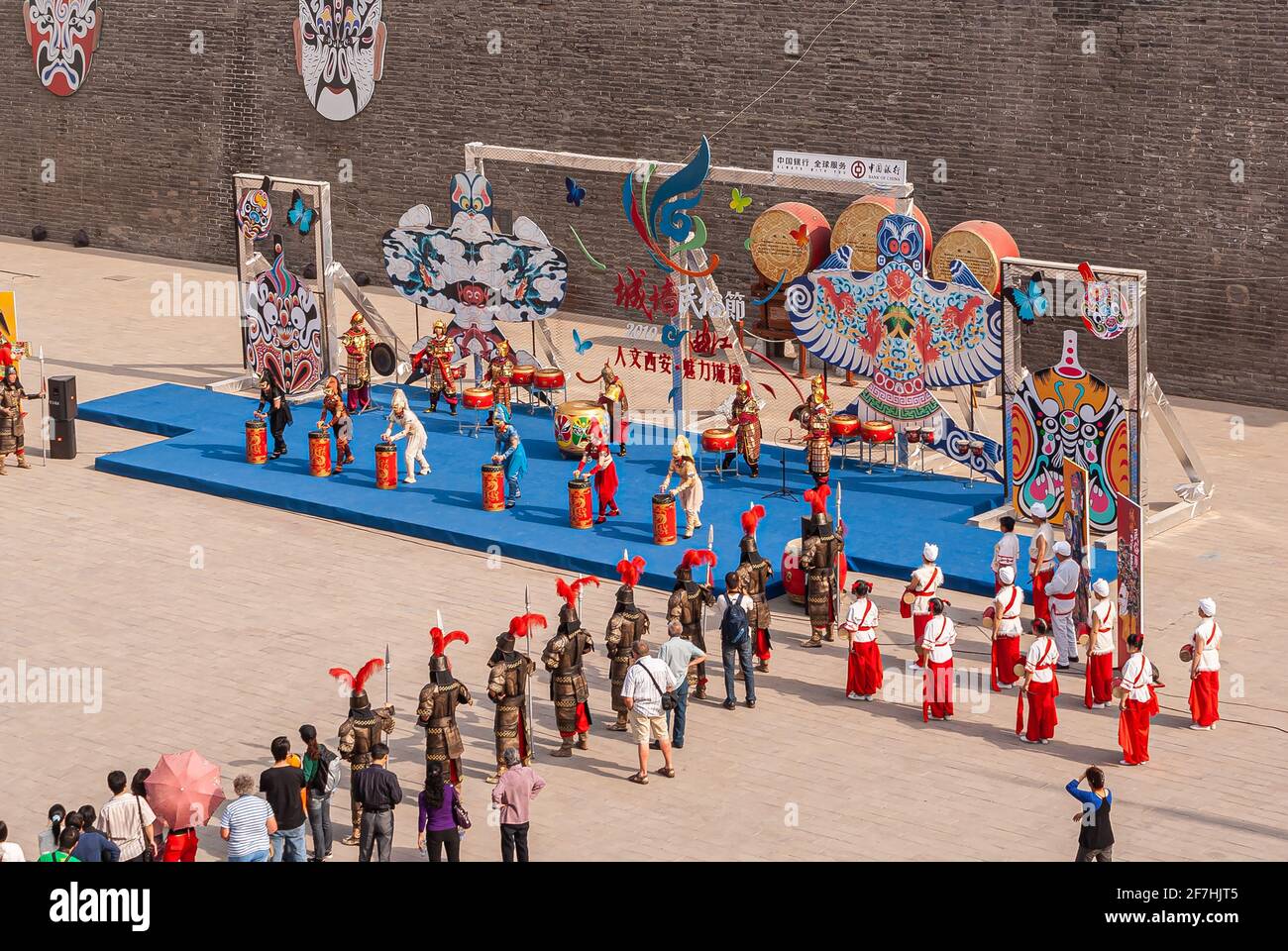 Xian, China - May 1, 2010: City Wall brown stone ramparts, South Gate. Performance in traditional colorful garb of music and dance on blue carpet in l Stock Photo