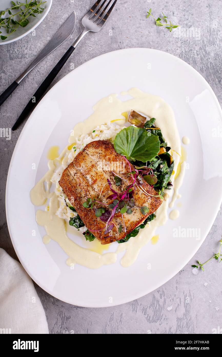 Sauteed fish with leafy greens and rice Stock Photo