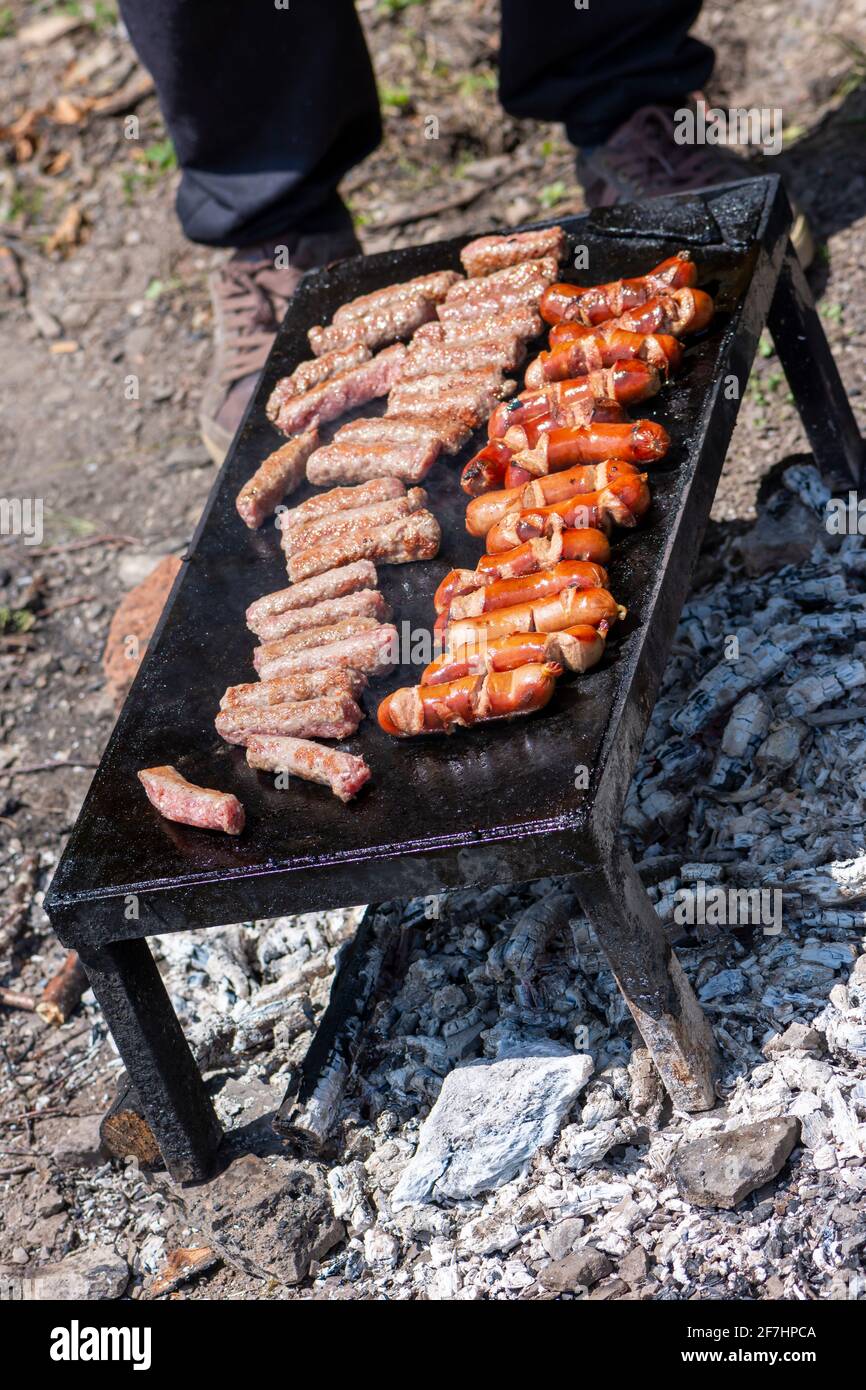 Grilling meat on bbq stone grill in nature Stock Photo - Alamy
