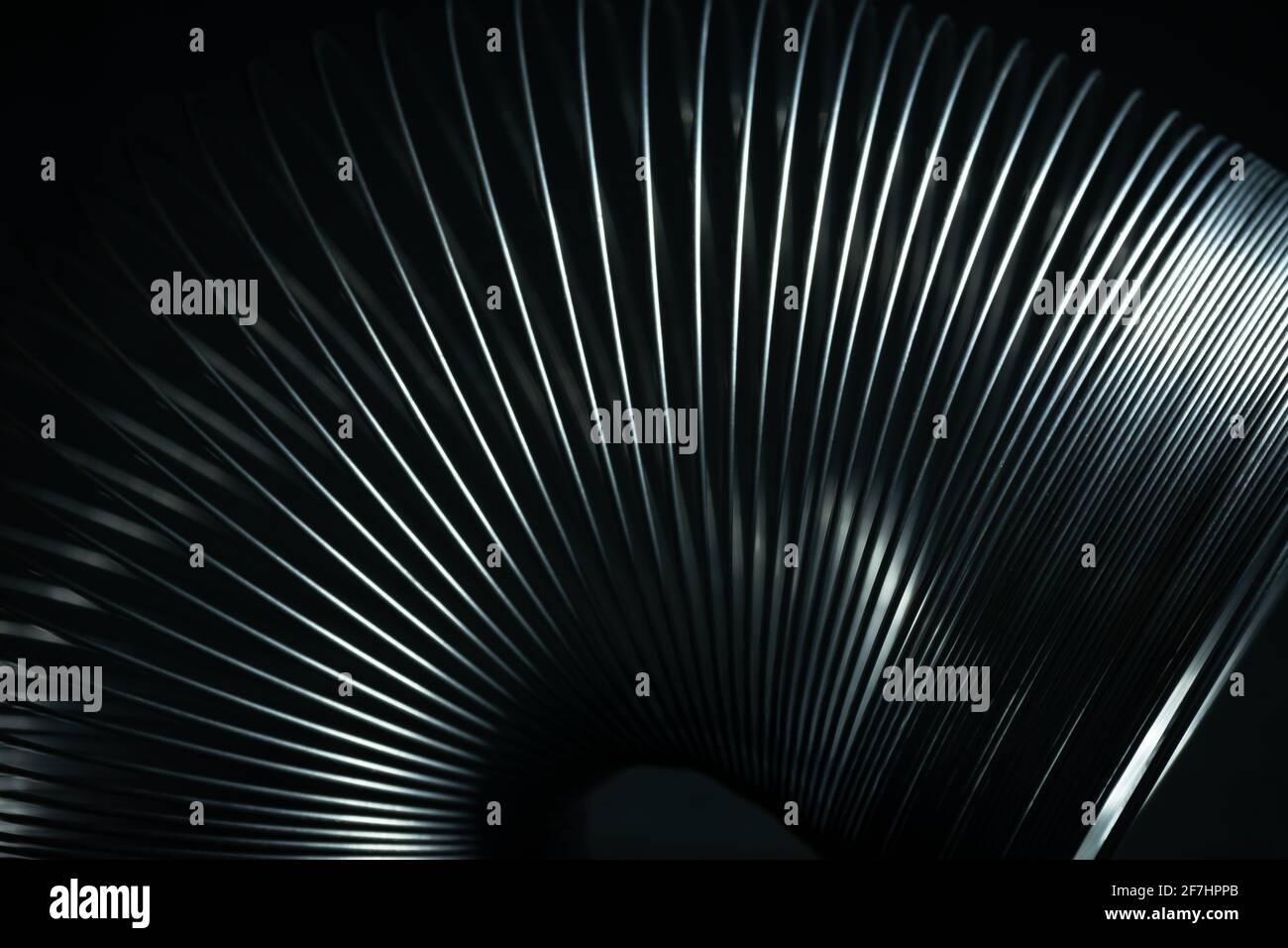 Metal spring toy with black background. Stock Photo
