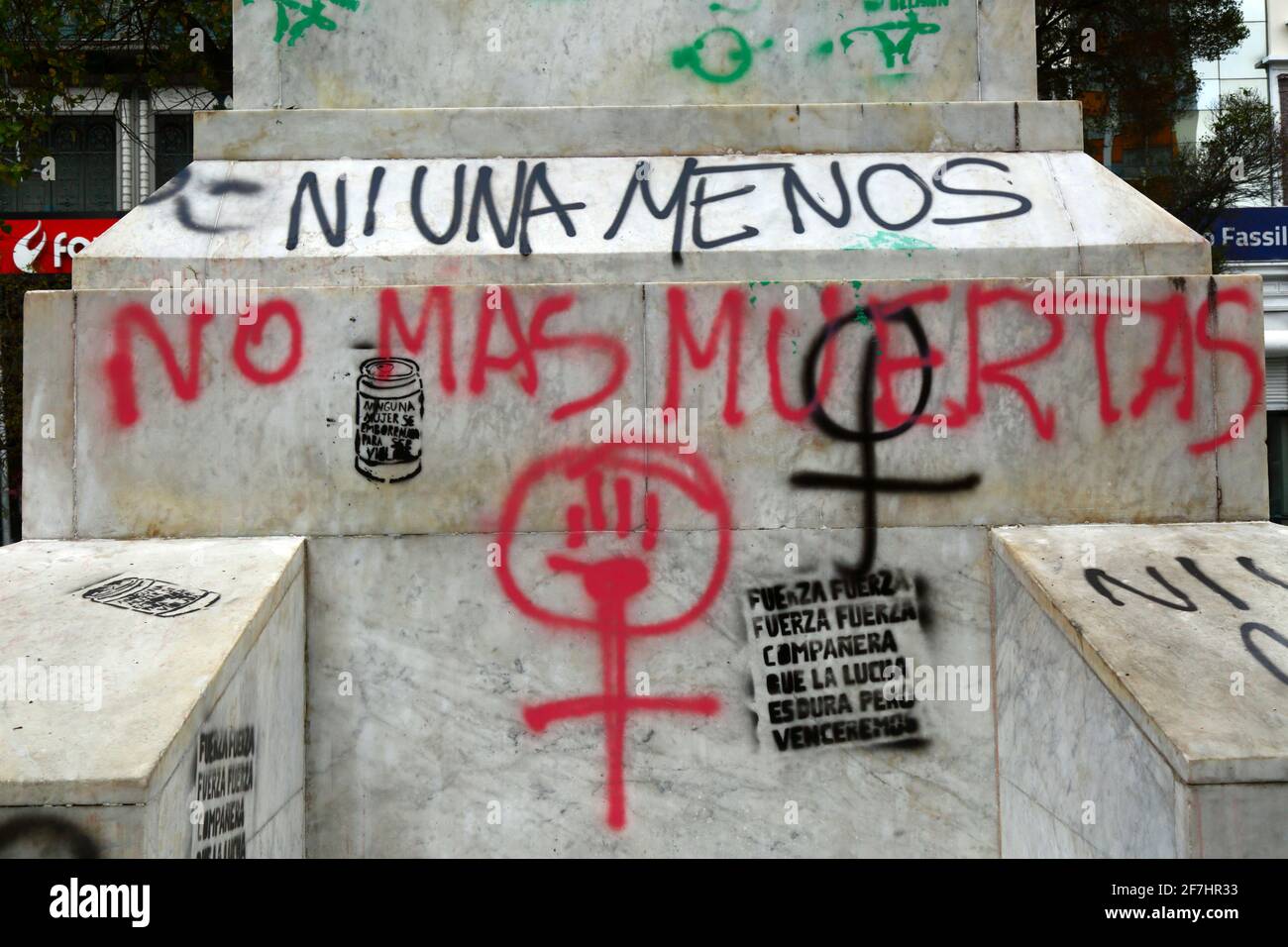 7th April 2021, El Prado, La Paz, Bolivia. Detail of graffiti by feminist groups on base of monument to Christopher Columbus, protesting against violence against women, the number of femicides and slowness of the justice system in dealing with cases. 'Ni una  menos ' means ' not one less'; 'no mas muertos ' means 'no more deaths' Stock Photo