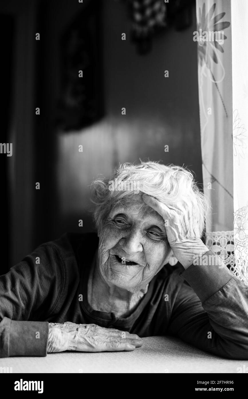 An old woman pensioner sit in her house. Black and white photo Stock ...