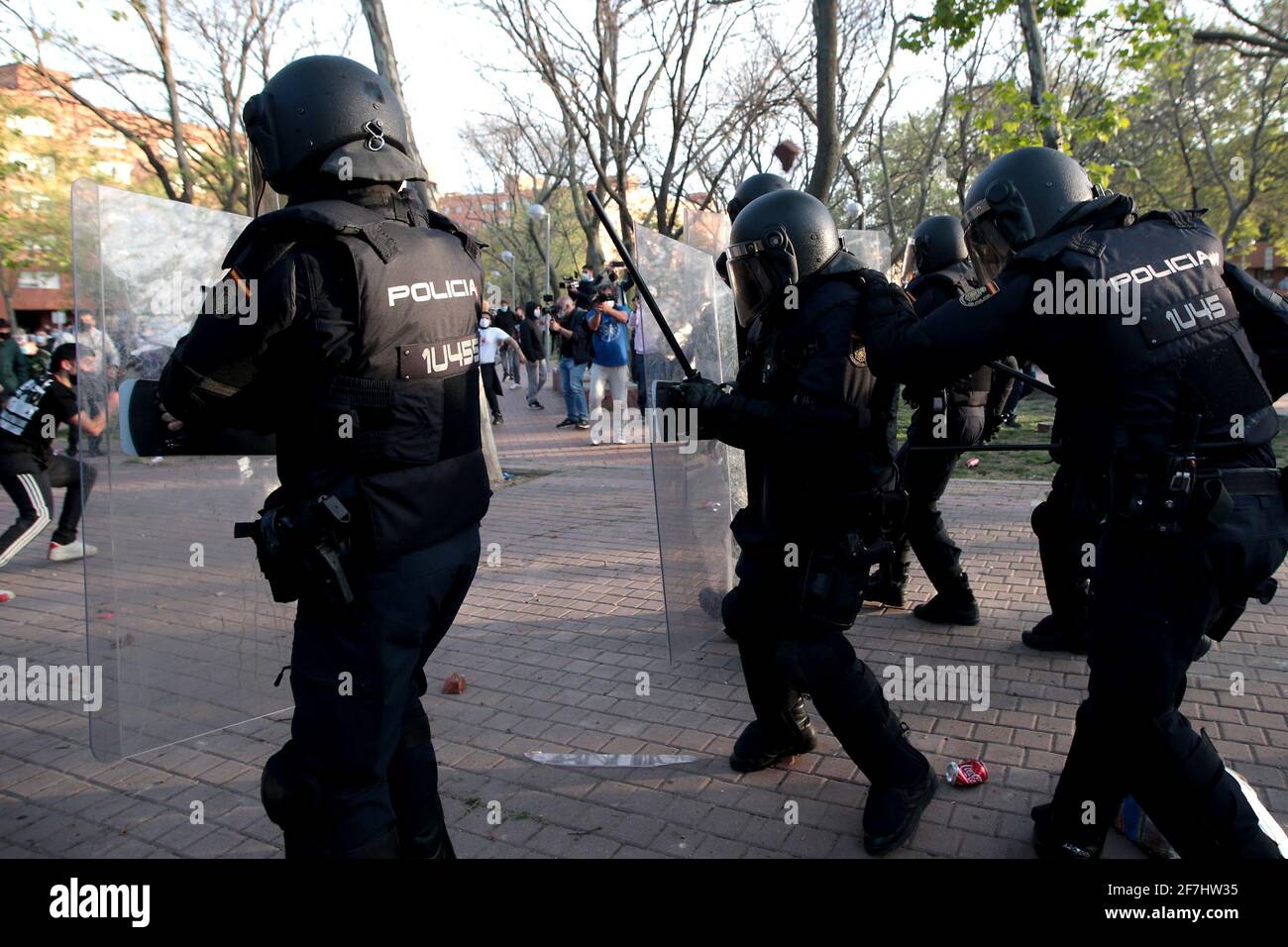 Madrid, Spain; 07.04.2021.- Police receive stones and other objects thrown by neighbors.Vox carries out its first act of electoral pre-campaign in Madrid in the working-class neighborhood of Vallecas. The National Police clash against residents of the Madrid neighborhood, who were protesting the pre-campaign act of the far-right party. The party's leader, Santiago Abascal, interrupted his rally and confronts several participants in the protests. Vox had gathered three hundred attendees in the popularly called 'Red Square' of Vallecas, separated by a narrow police cordon, the residents of the n Stock Photo